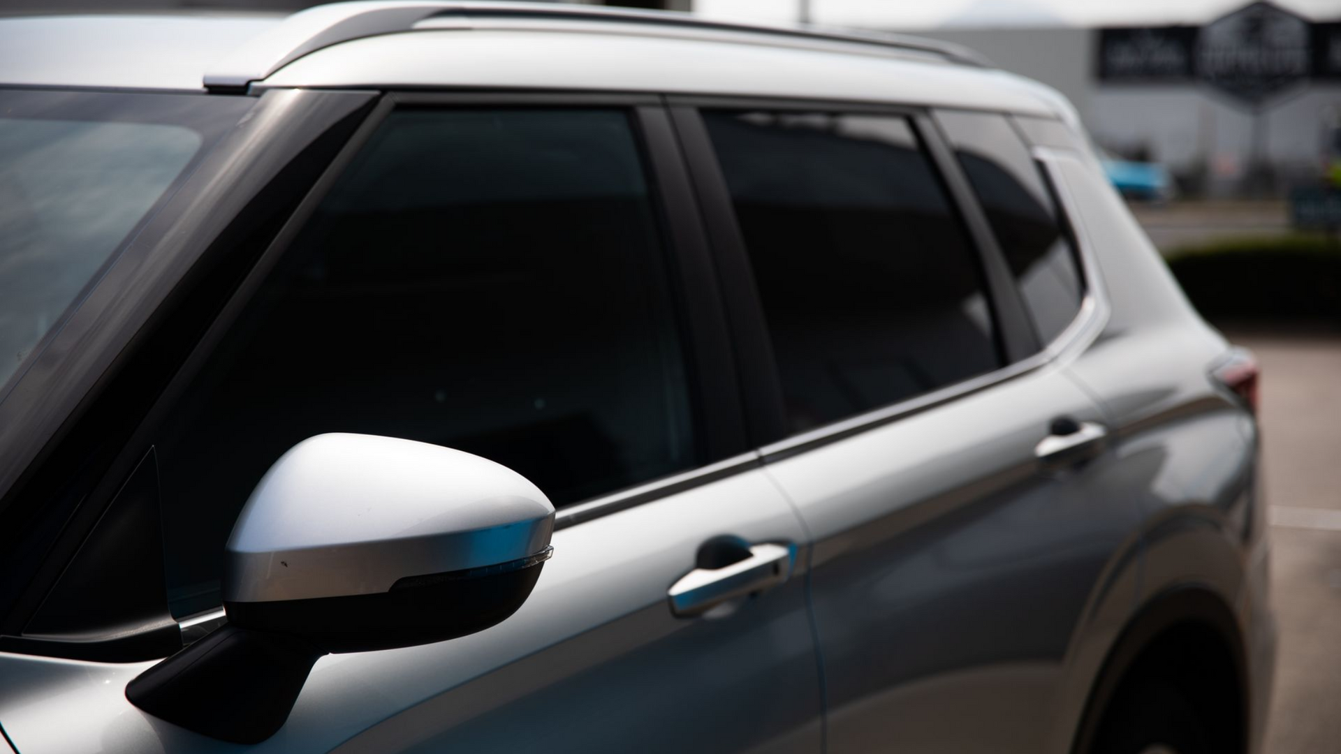 A man is applying tinted glass to a car window.