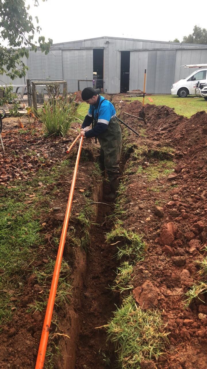 Male Technician In Blue Uniform Repairing Air Conditioner Indoors — John B Electrical In Beechworth VIC