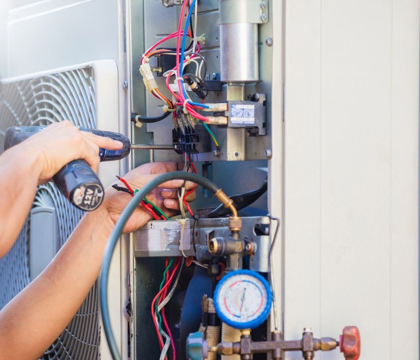 Male Technician Hands Using A Screwdriver Fixing Modern Air Conditioner — John B Electrical In Corowa NSW