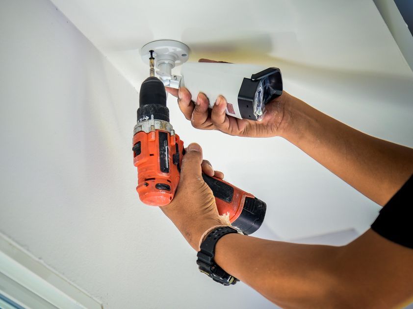 Technician Installing CCTV Camera System On The Ceiling — John B Electrical In Wooragee VIC