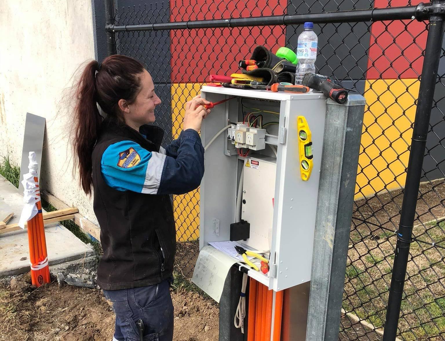 Woman Working On An Electrical Box