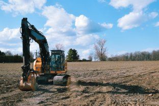 Excavator in a vacant land in Wollongong NSW preparing for subdivision to build houses.