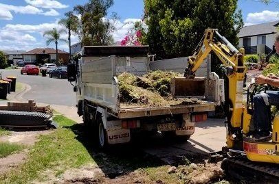 Mini excavator moving excavated turf in Kiama NSW residential property