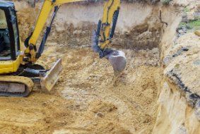 A excavator during earthworks backhoe digging ground during earthworks for preparation of subdivision in Wollongong NSW.