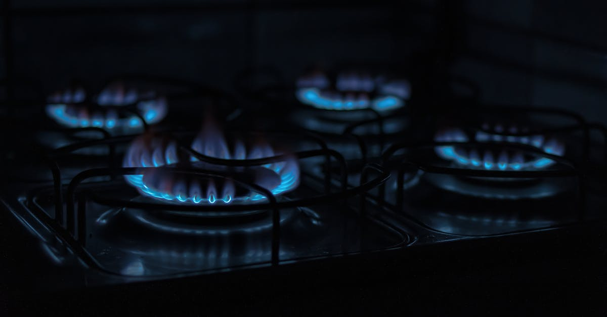 A close up of a gas stove with blue flames in the dark by D&D Construction Nottingham, Derby