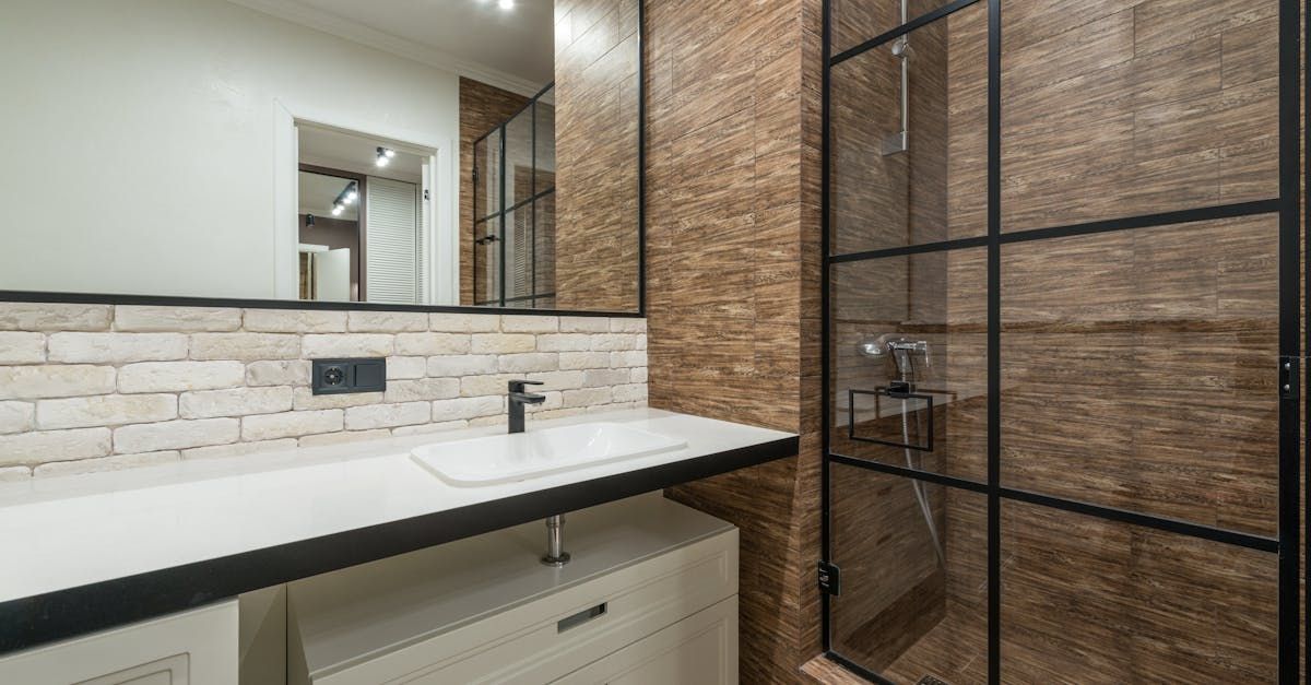 A bathroom with a sink , mirror and walk in shower built by .D&D Construction Nottingham