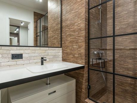 A bathroom with a sink , mirror and shower stall. D&D Construction Nottingham