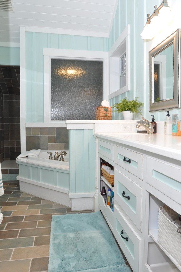 A bathroom with a tub , sink and mirror