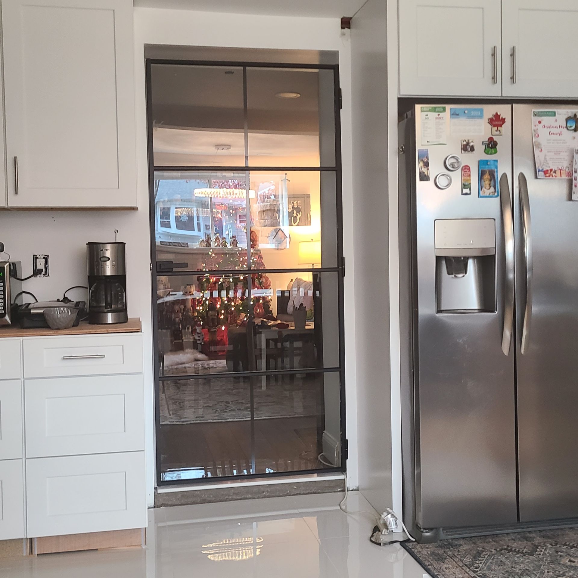 A kitchen with a stainless steel refrigerator and a glass door