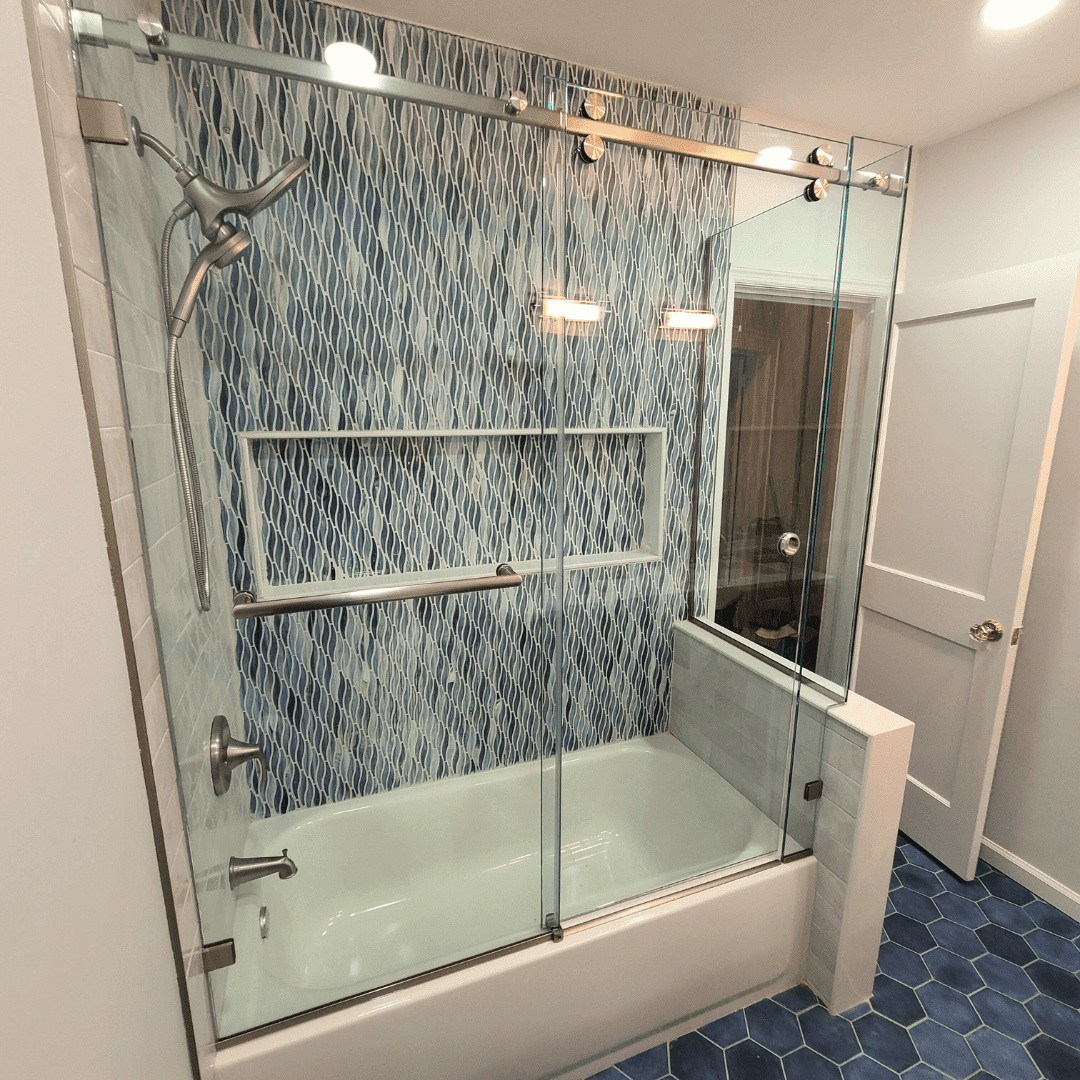 A bathroom with a bathtub and a shower with sliding glass doors.