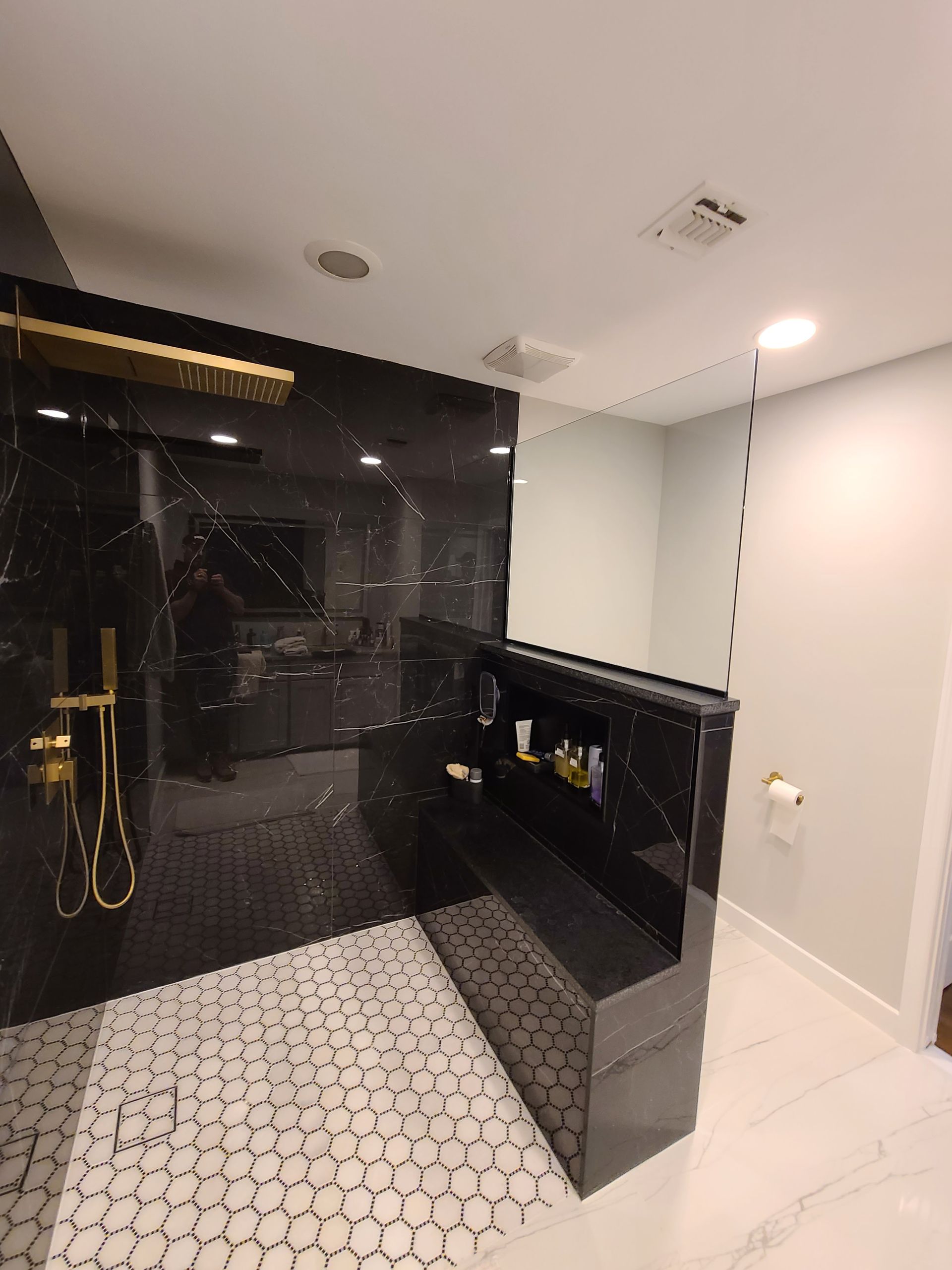 A bathroom with a walk in shower , sink and mirror.