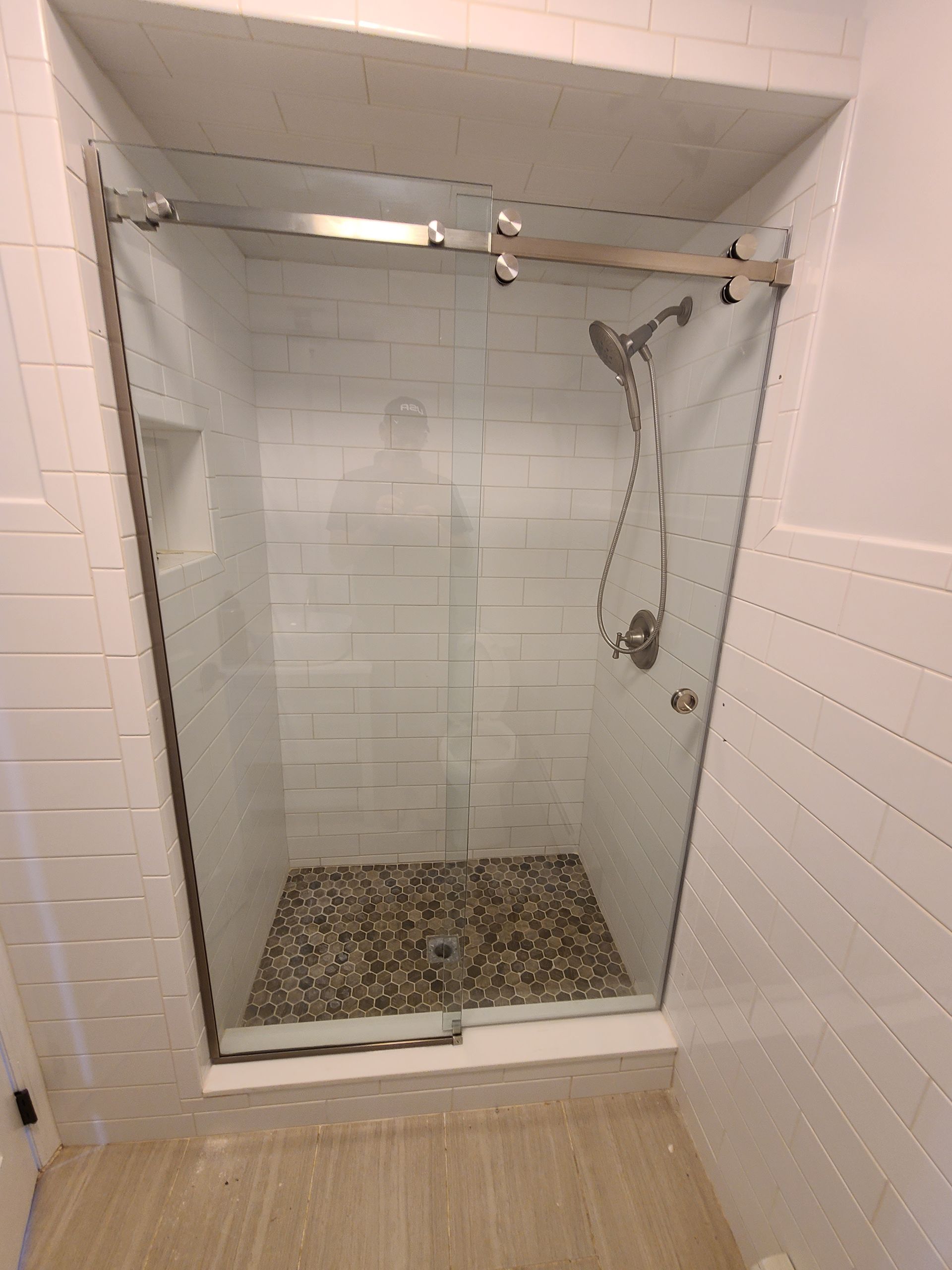 A bathroom with a sliding glass shower door and a shower head.