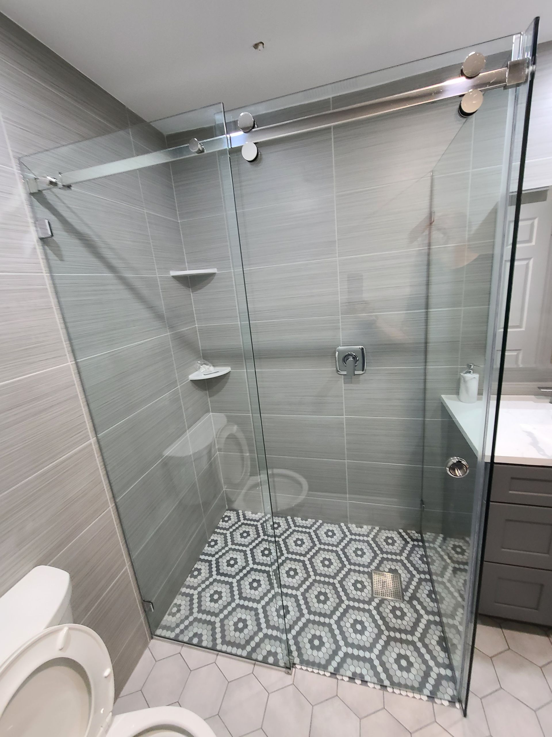 A bathroom with a walk in shower and a toilet