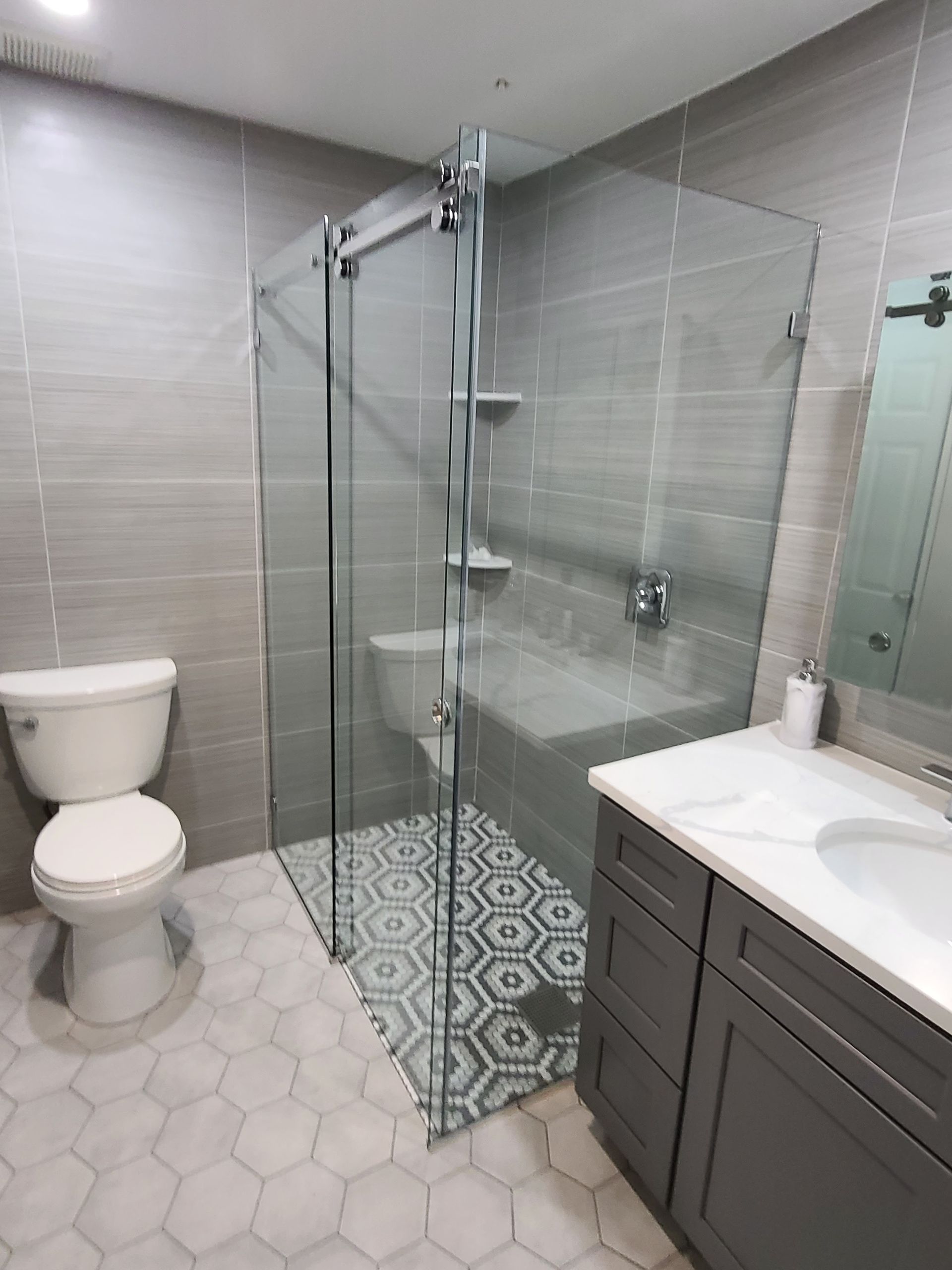 A bathroom with a toilet , sink , and walk in shower.