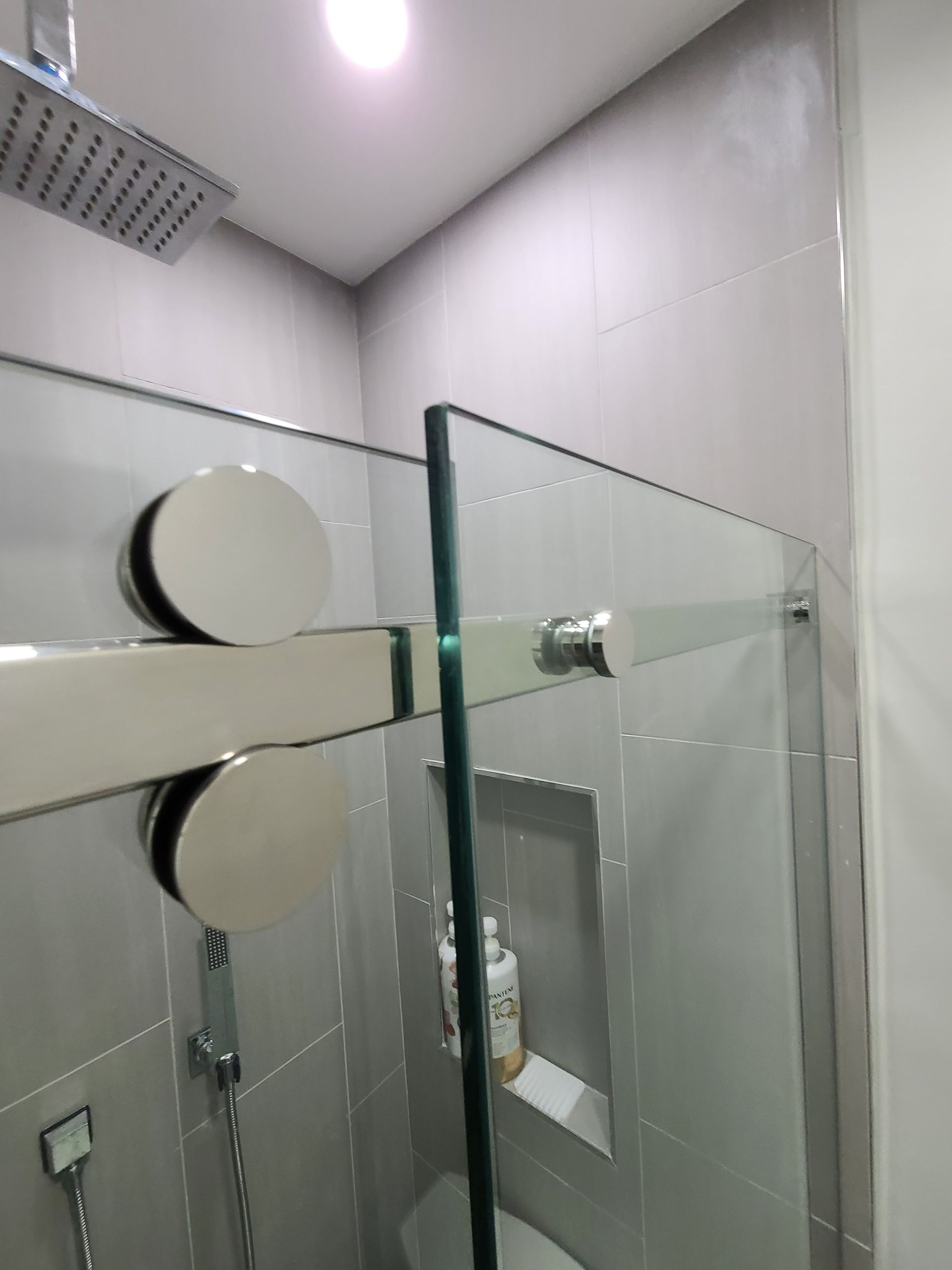 A bathroom with a sliding glass shower door and a toilet.