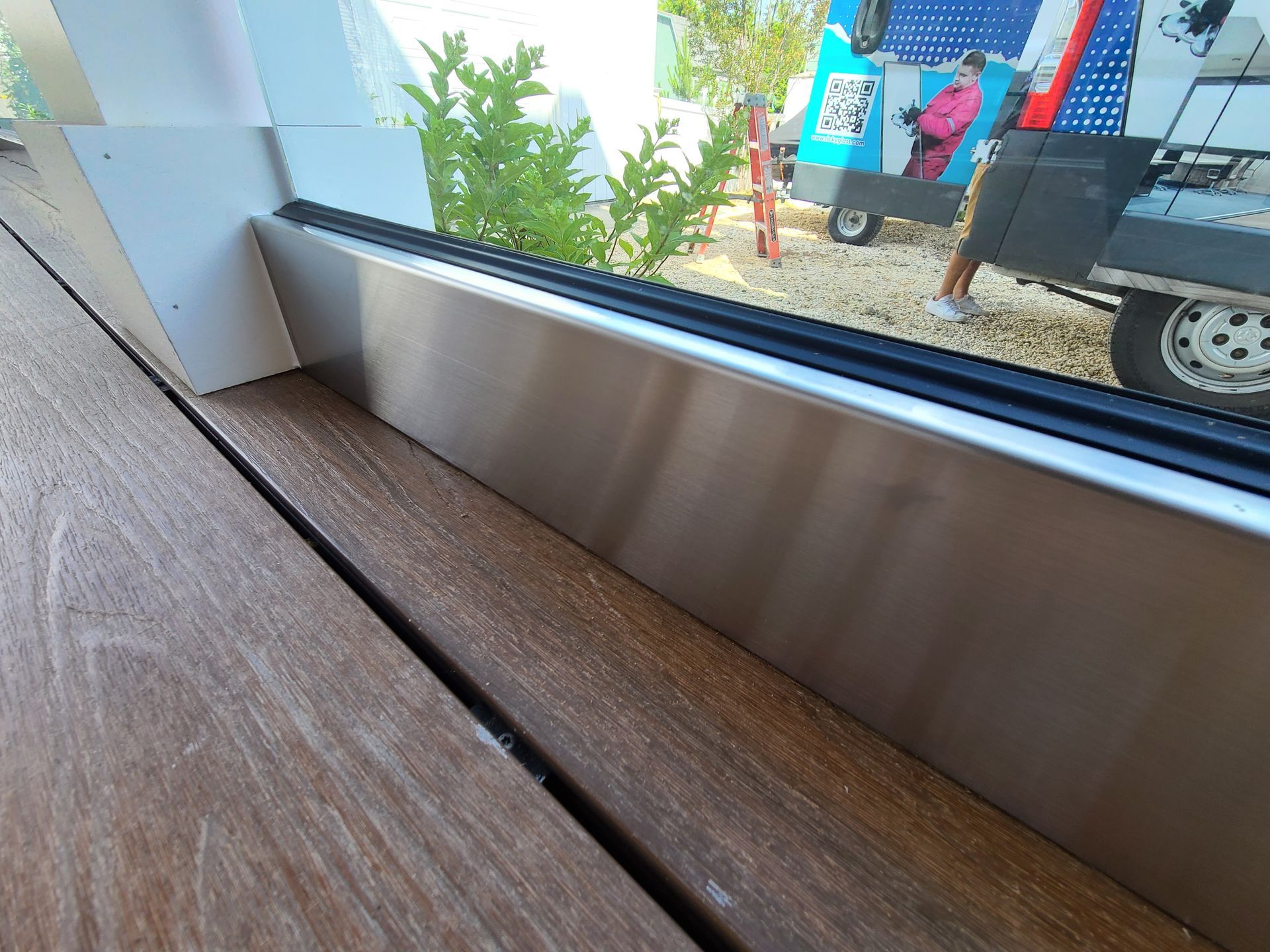 A close up of a window with a stainless steel trim