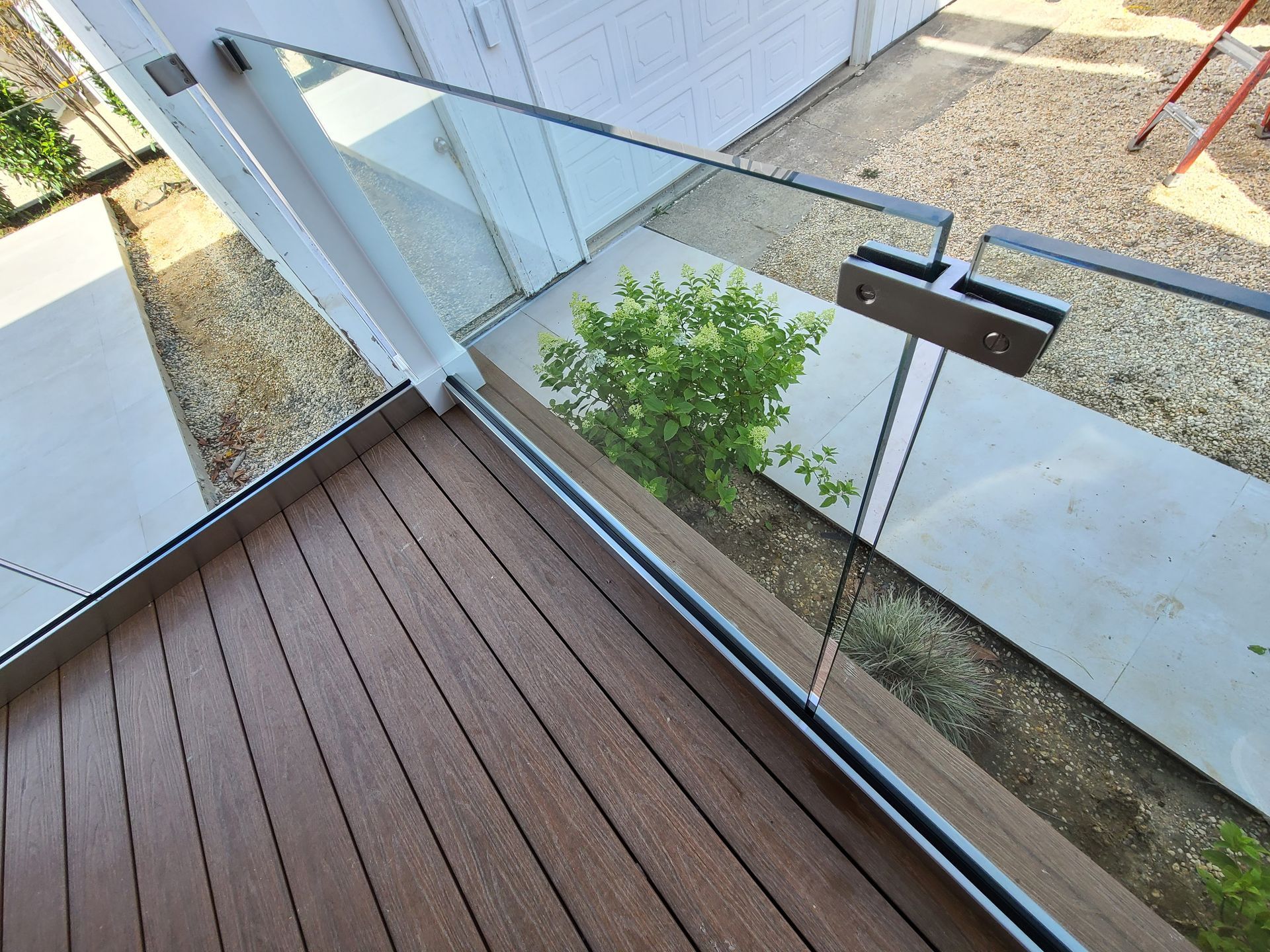A balcony with a glass railing and a wooden deck.