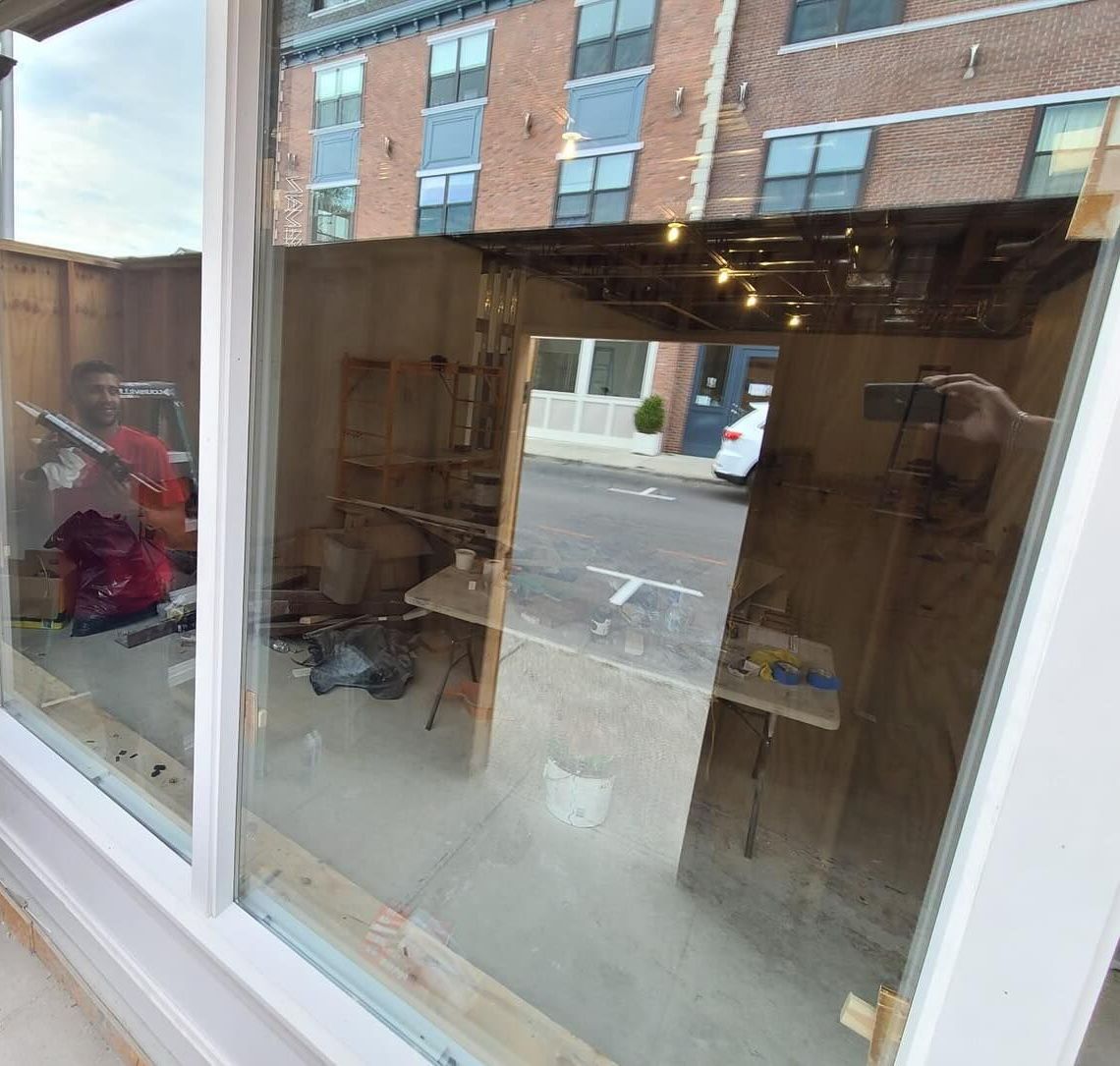 A man is installing a window in a building.