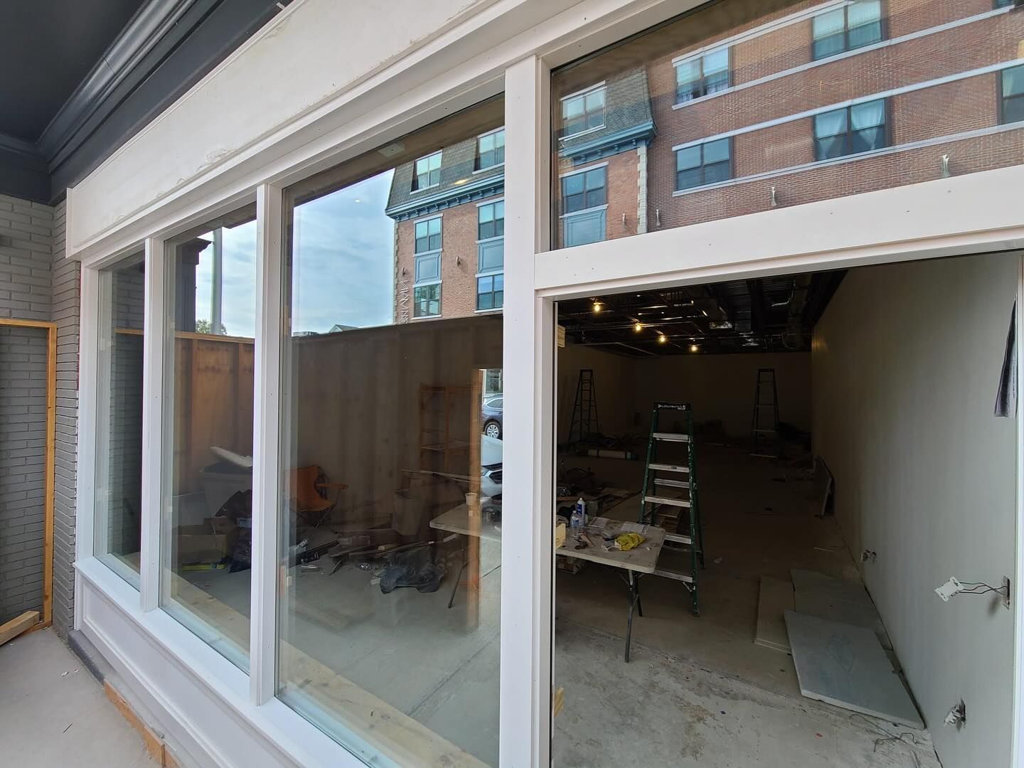 A room with a lot of windows and a brick building in the background.