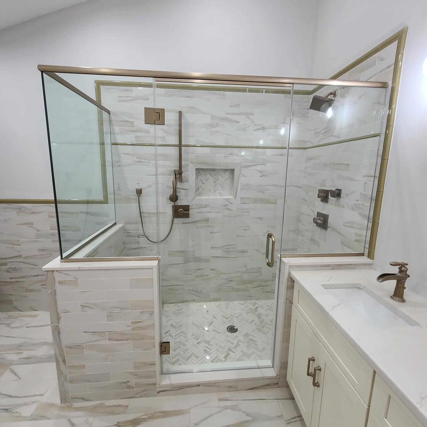 A bathroom with a walk in shower and a sink