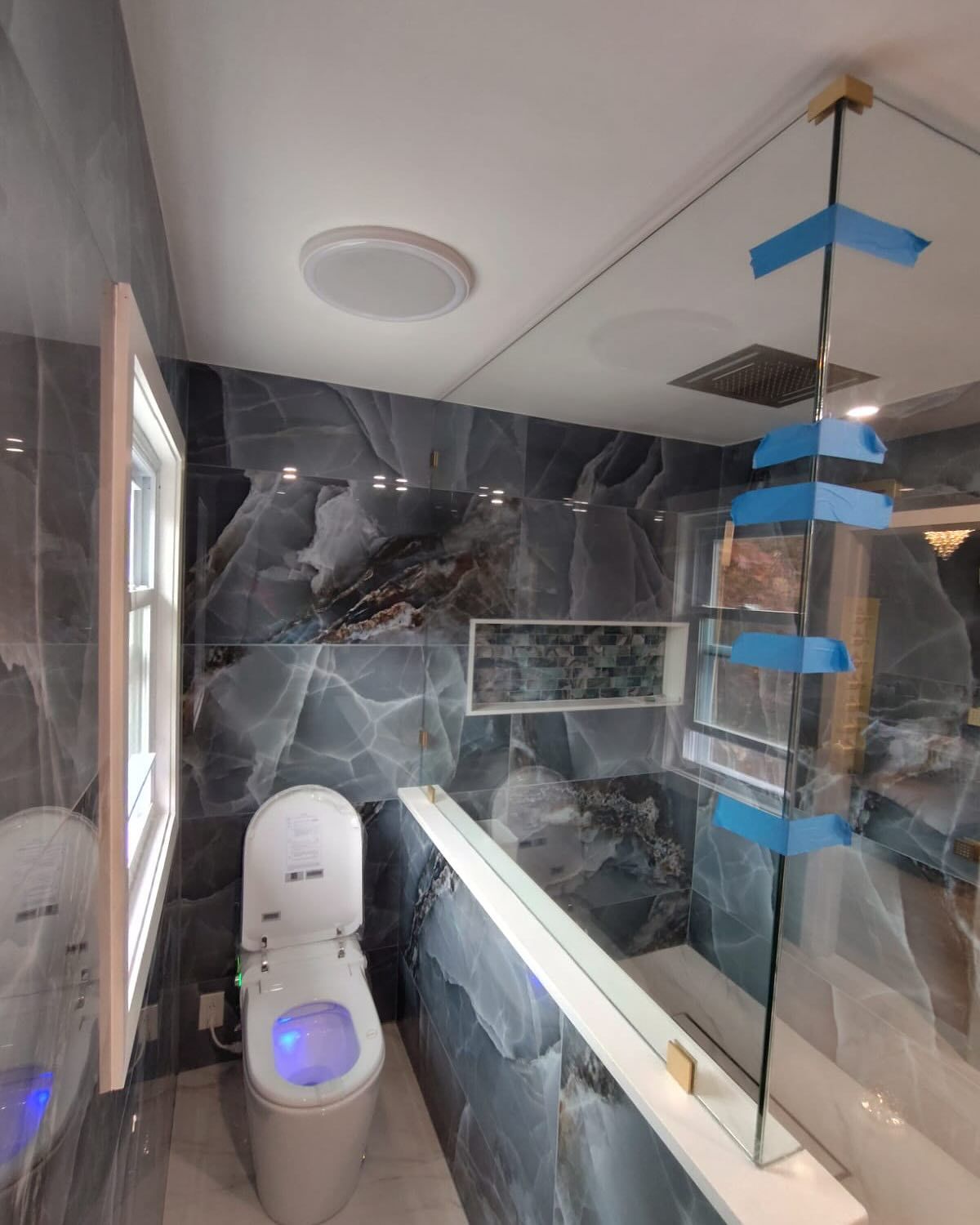 A bathroom with a toilet , shower , and mirror.