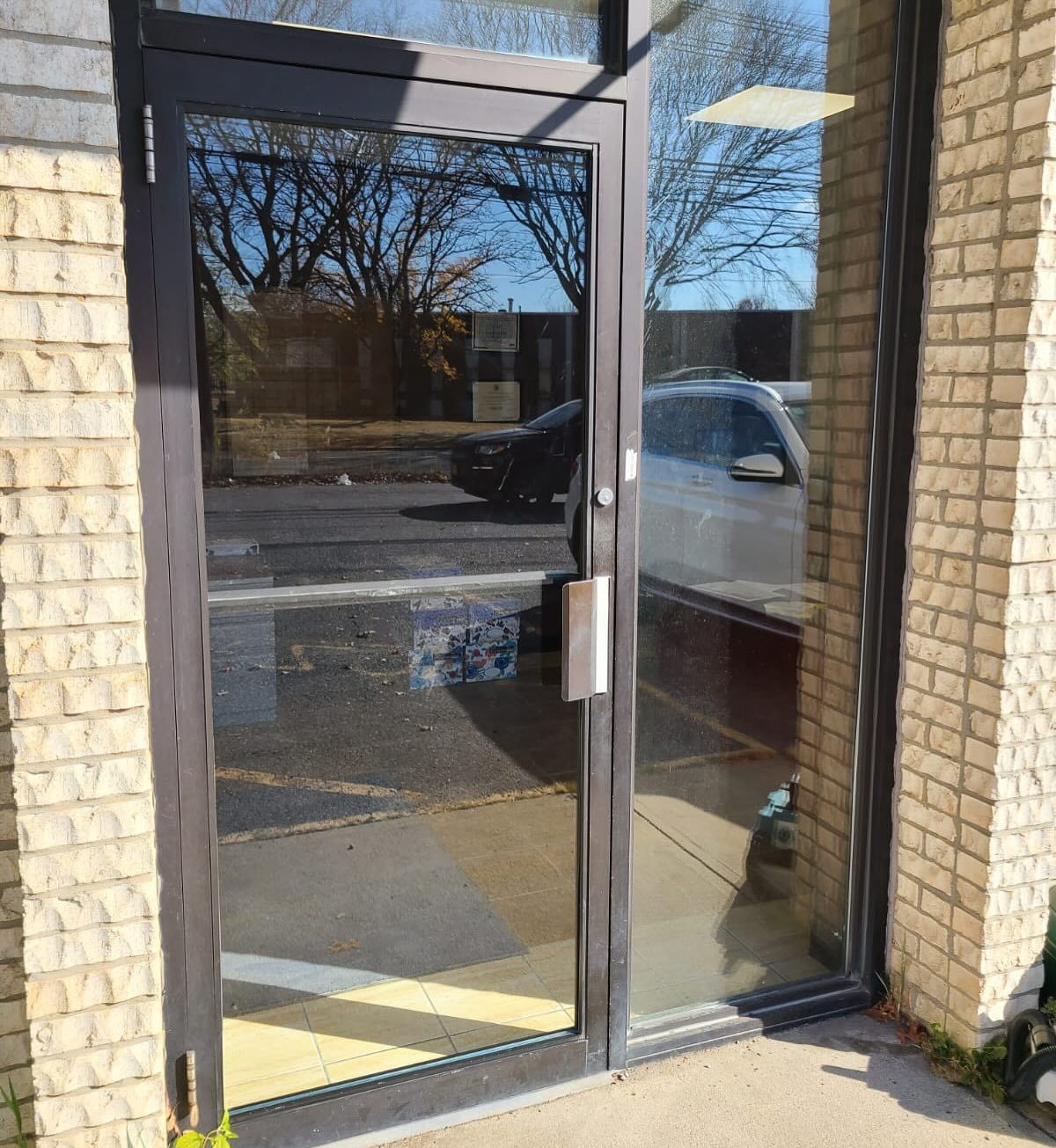 A glass door with a brick wall behind it