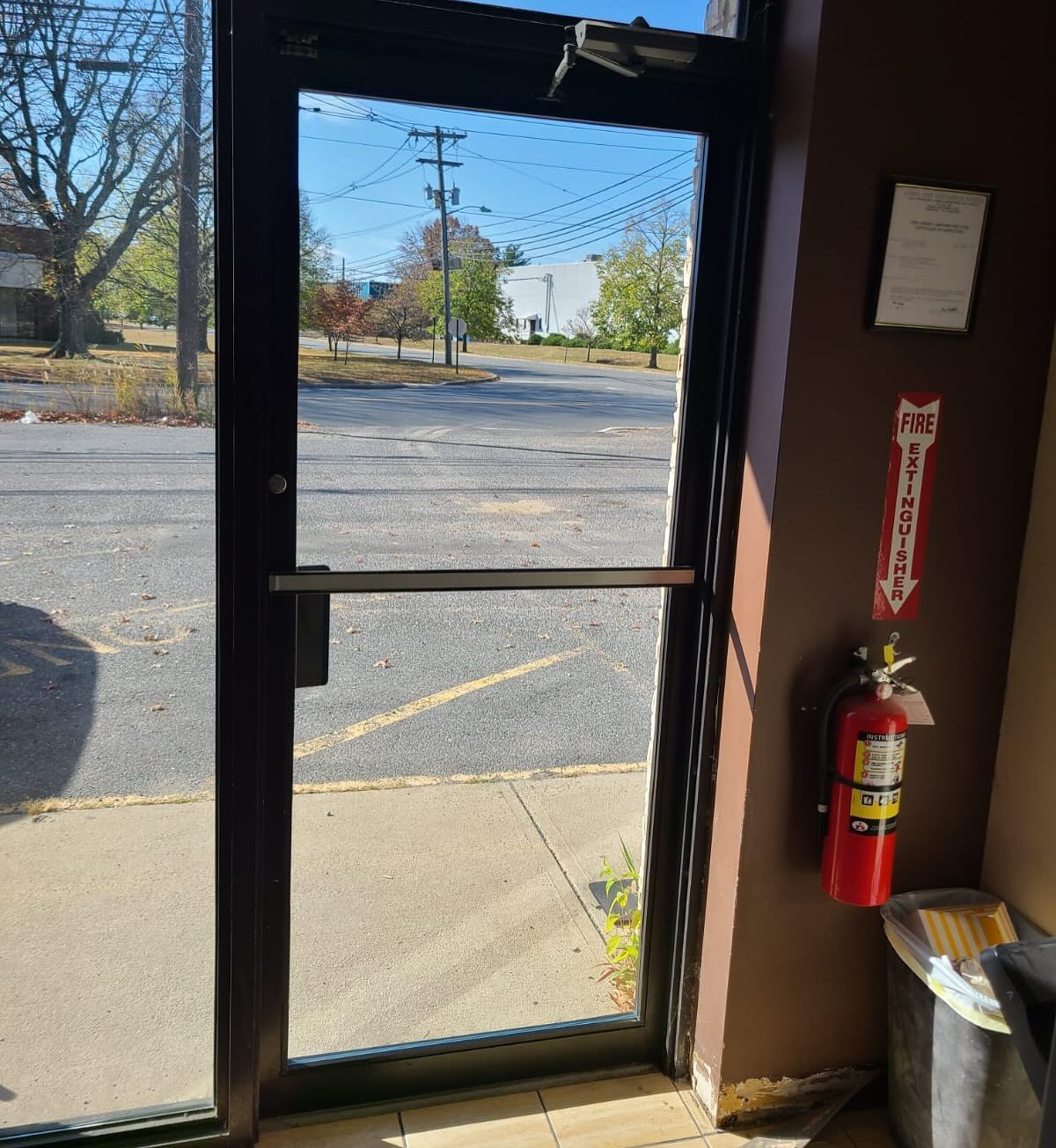 A fire extinguisher is next to a glass door