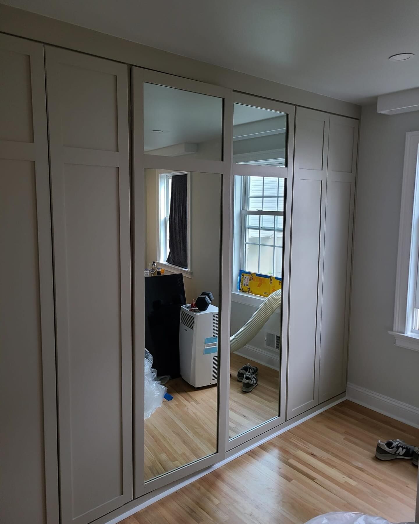 A bedroom with a lot of closets and mirrors.