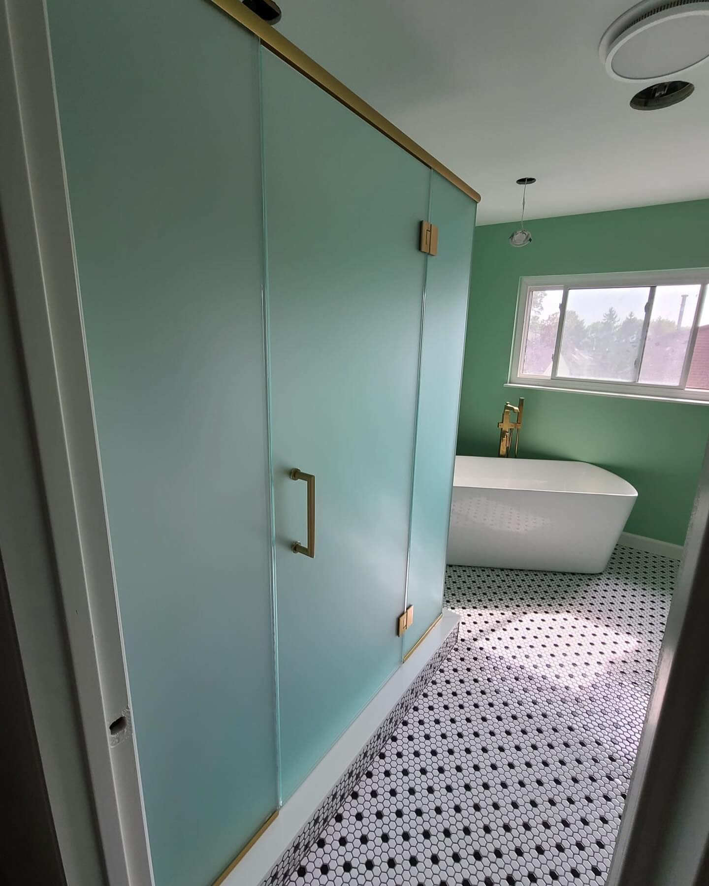 A bathroom with green walls and a white bathtub