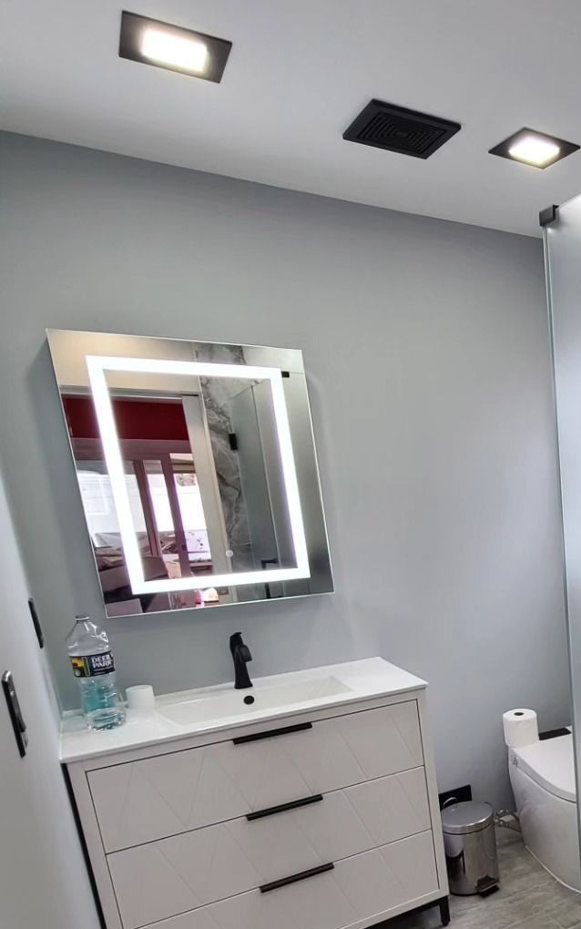 A bathroom with a sink , mirror and toilet.