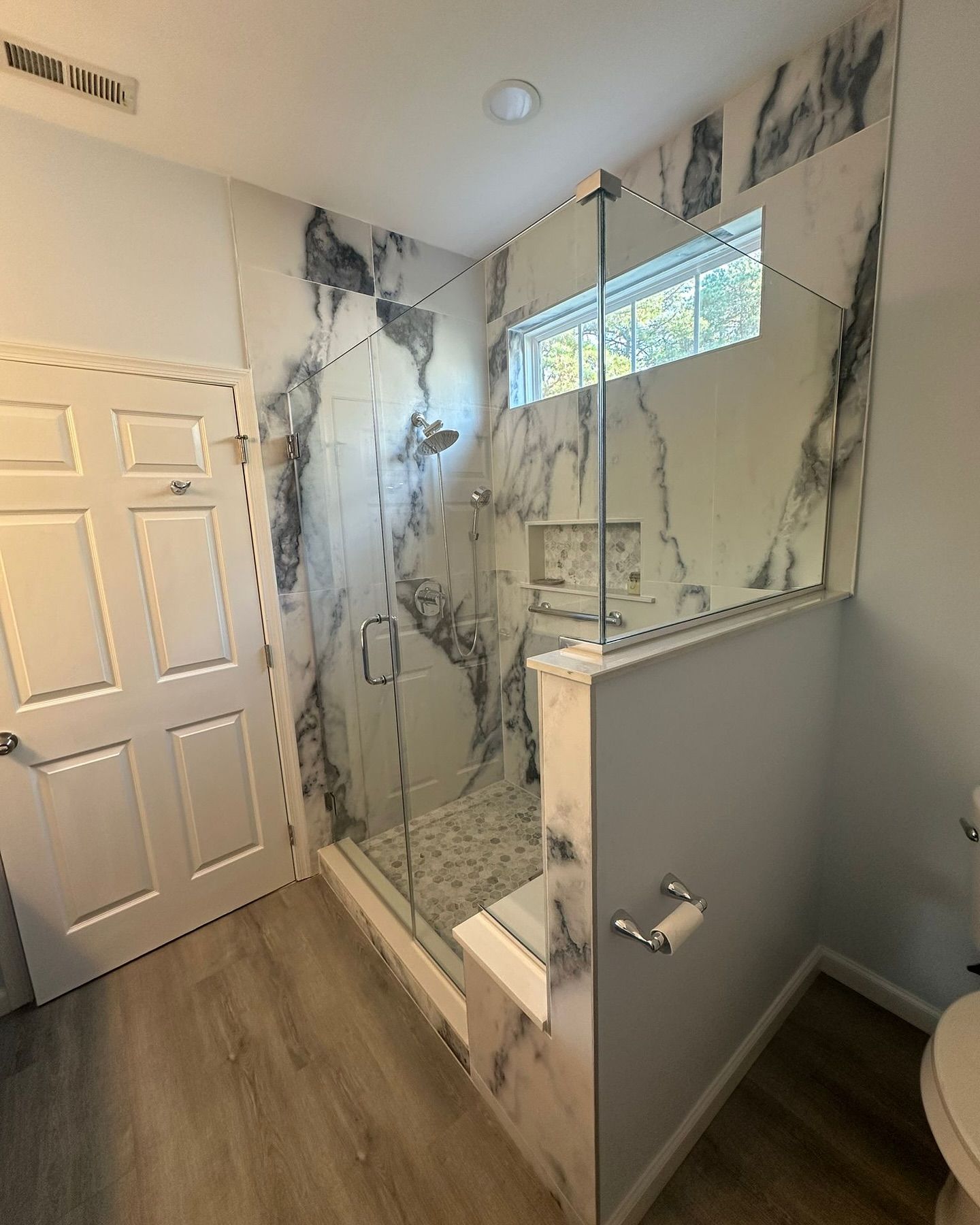 A bathroom with a walk in shower and a toilet.