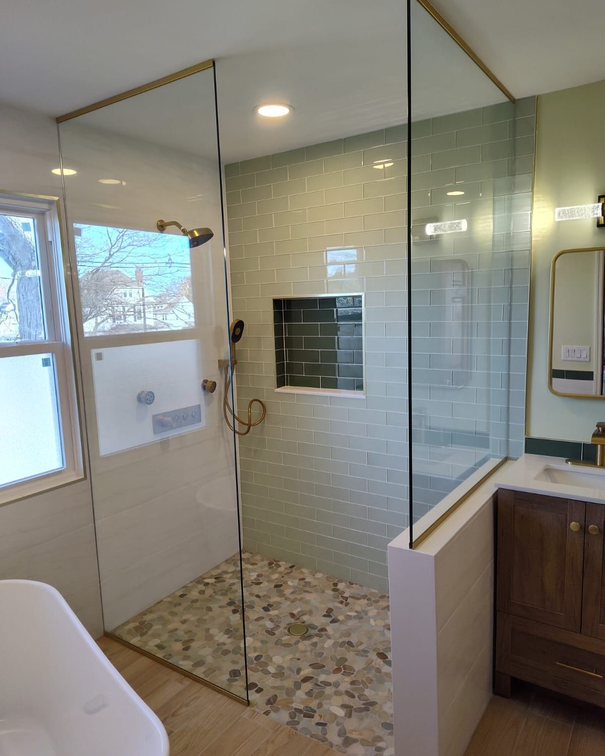 A bathroom with a walk in shower and a sink