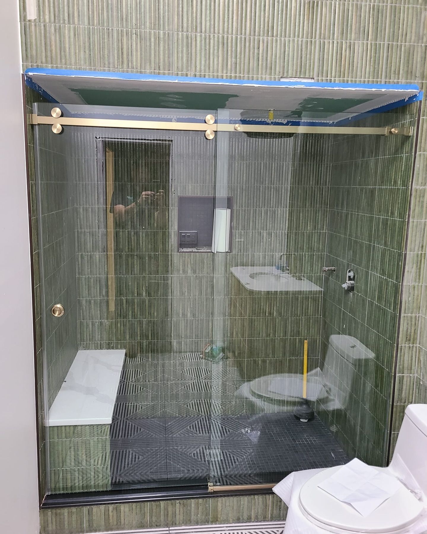 A bathroom with a sliding glass shower door and a toilet.