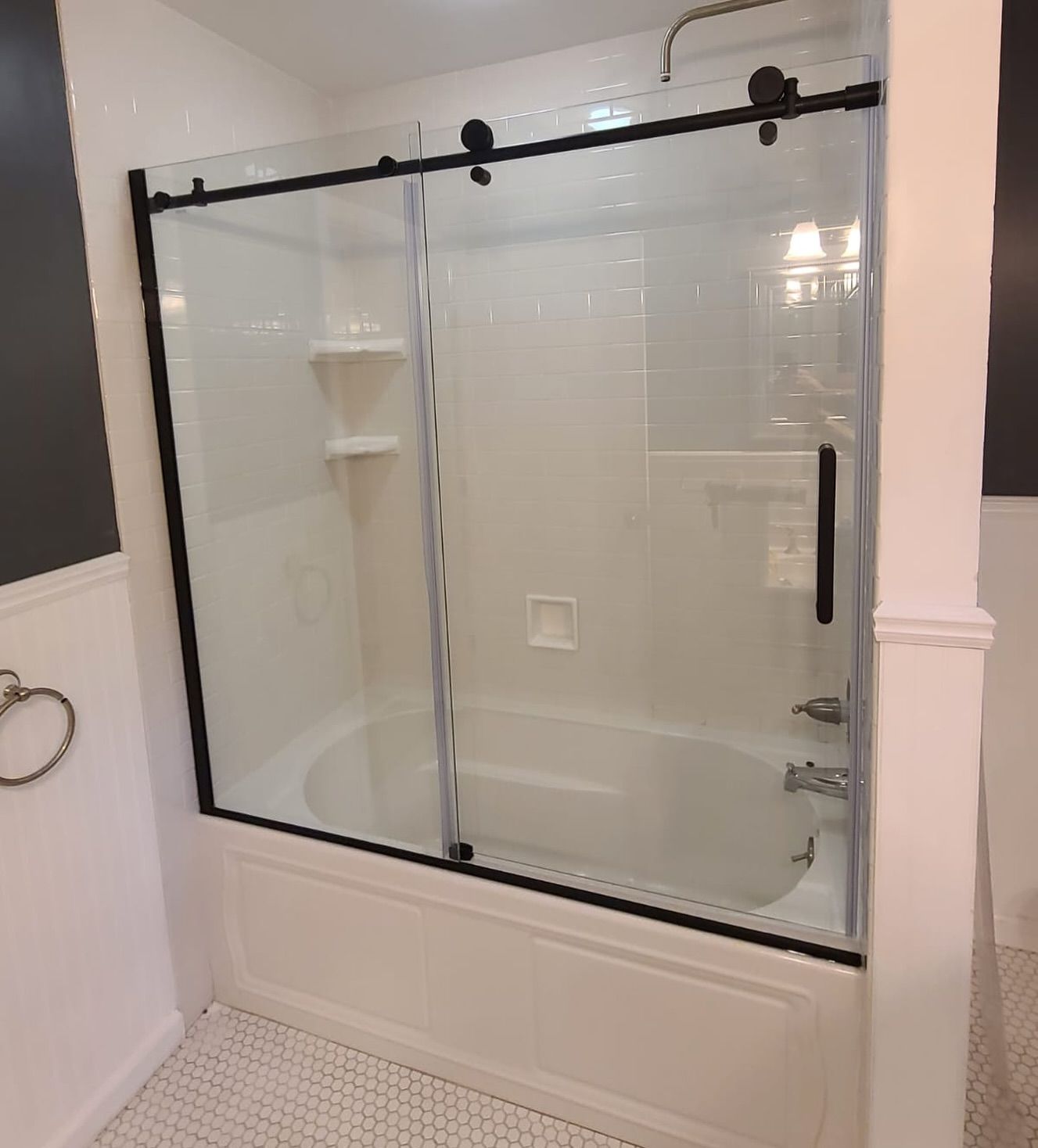 A bathroom with a bathtub and a sliding glass shower door.