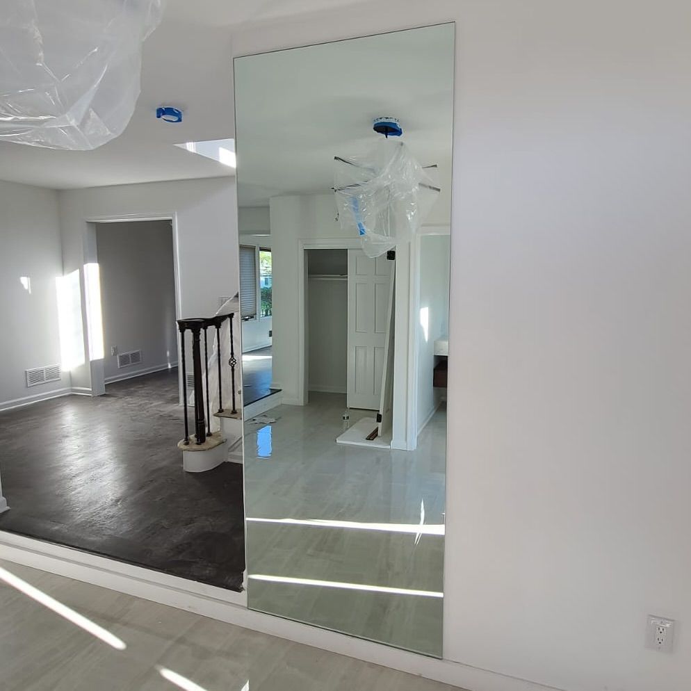 A large mirror is hanging on a wall in a room.