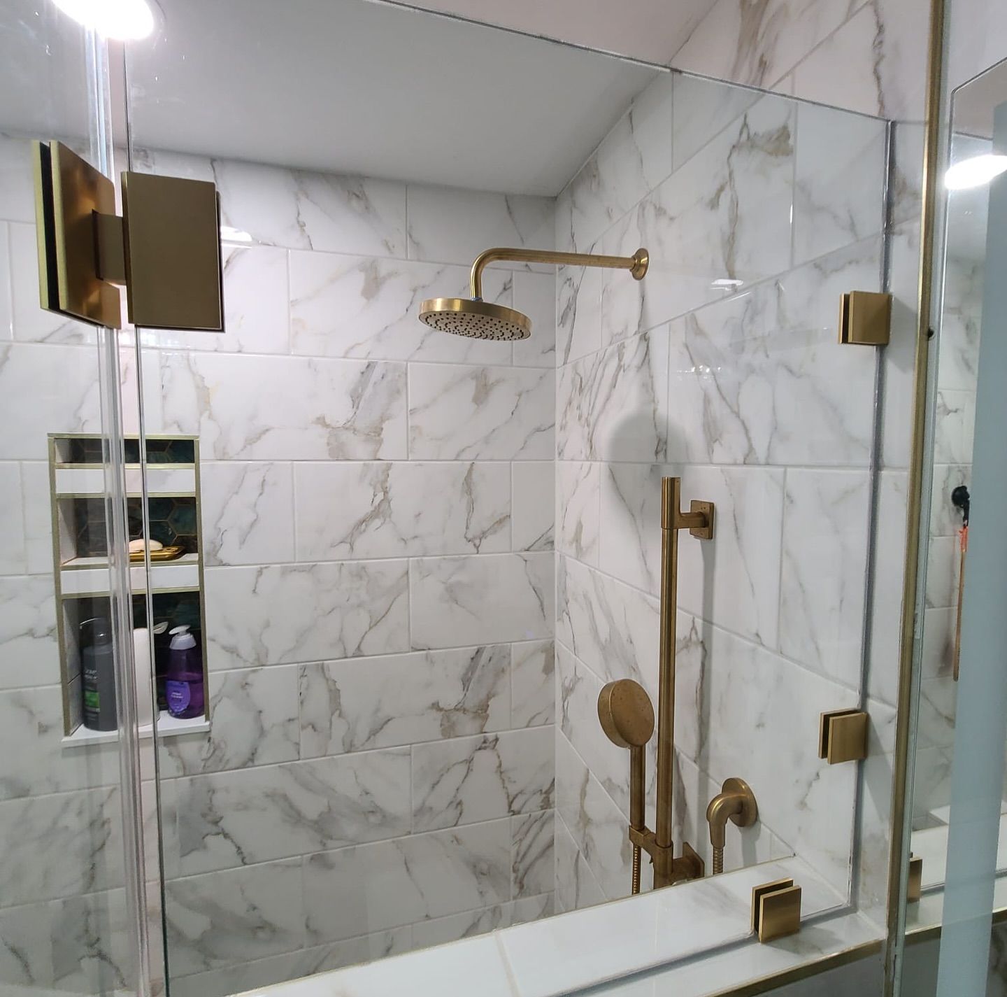 A bathroom with marble tiles and a shower head