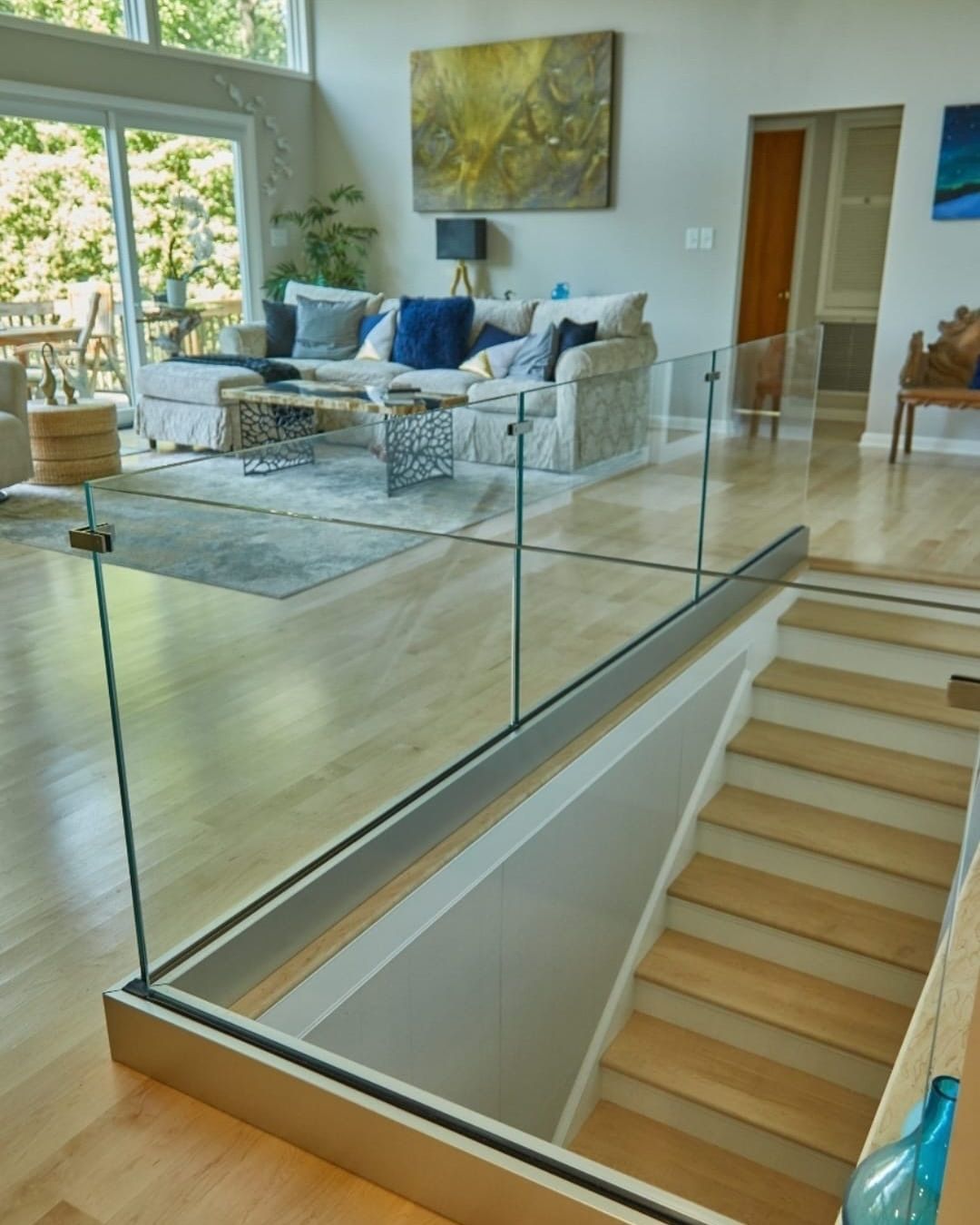 A living room with stairs and a glass railing