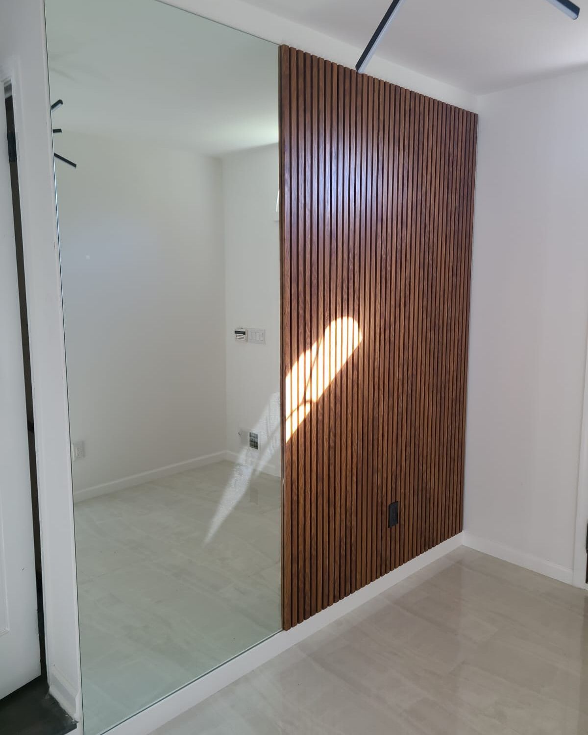 A room with a large mirror and a wooden wall