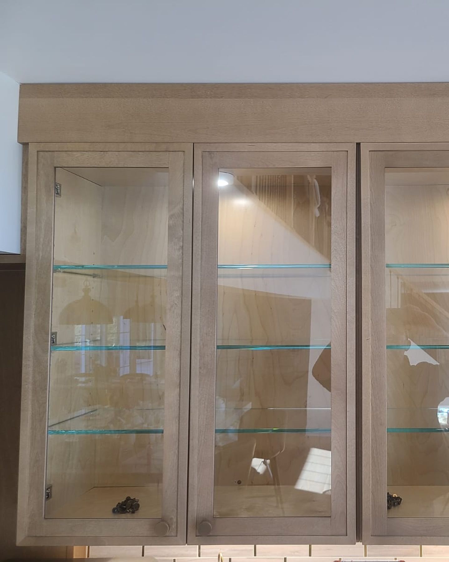 A wooden cabinet with glass doors and shelves