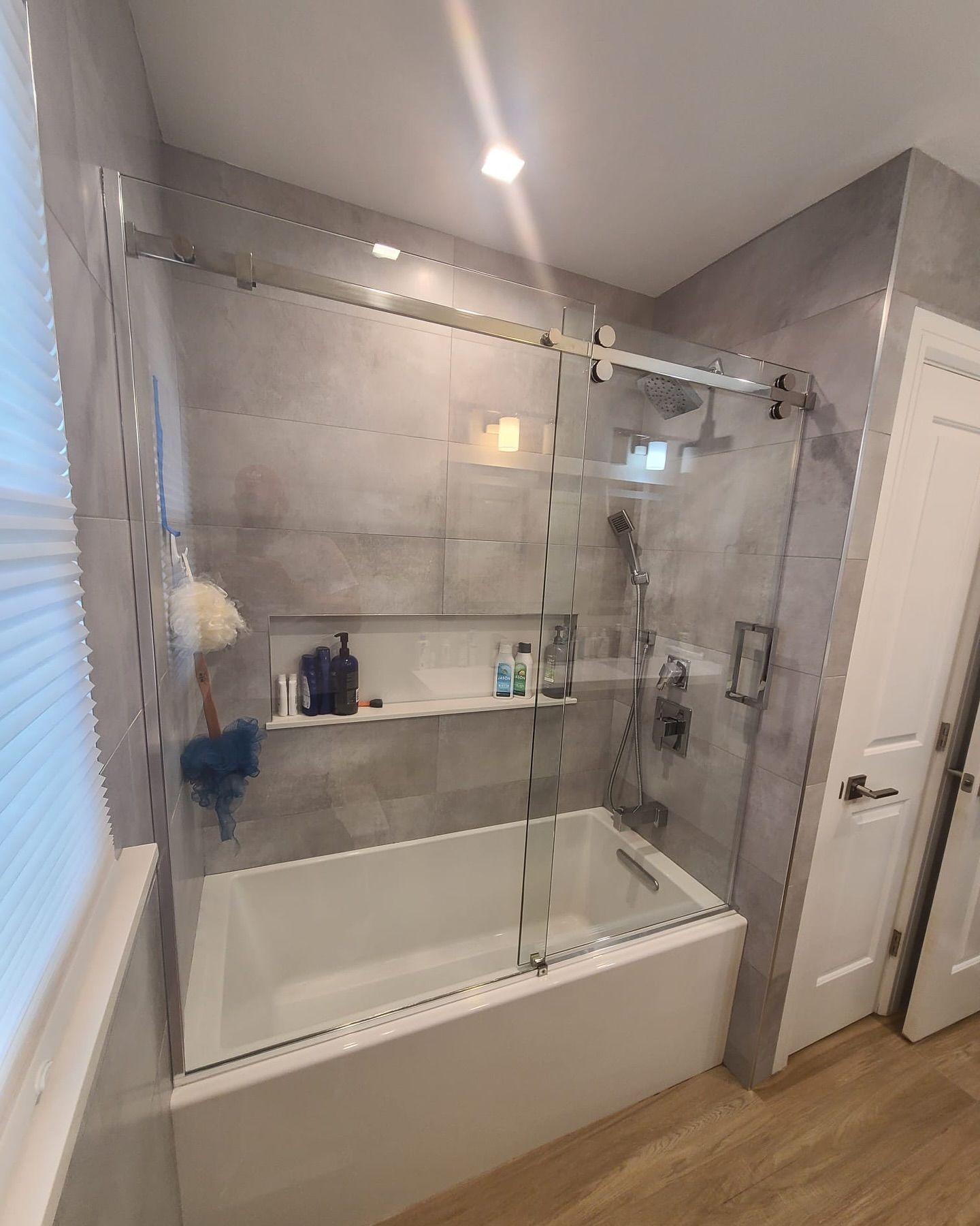 A bathroom with a tub and a shower with a glass door.