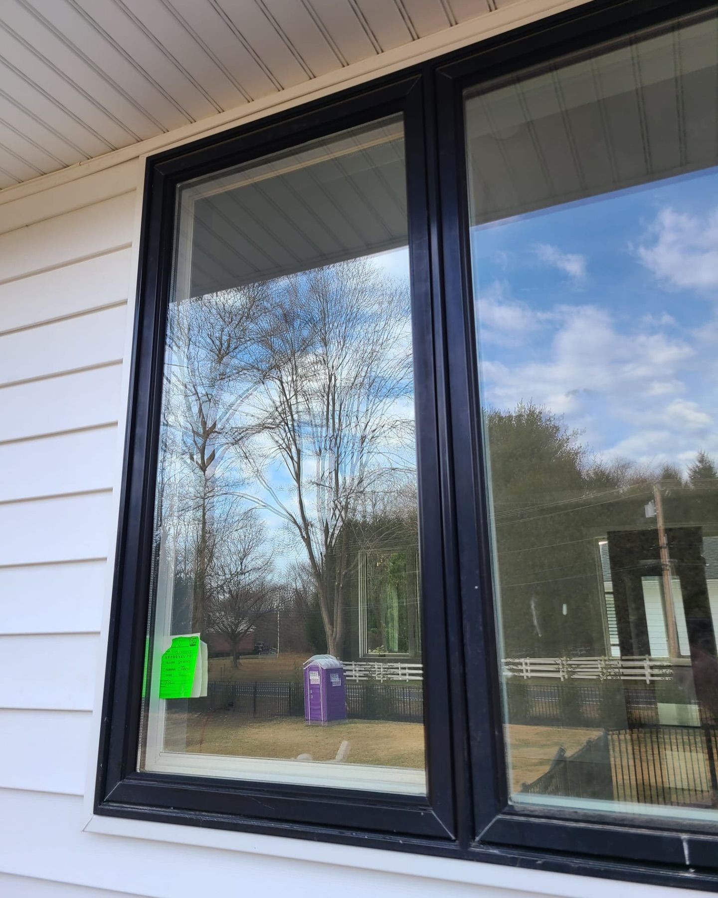 A window on a white house with a black frame