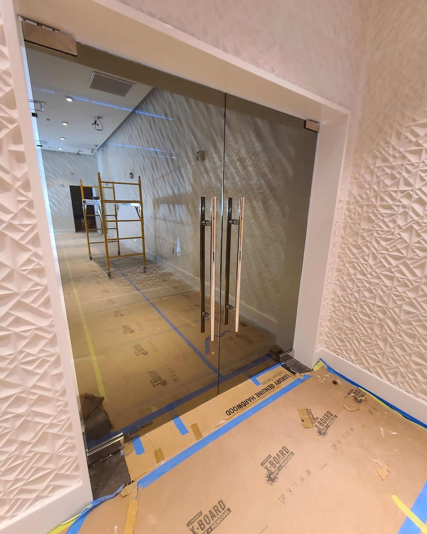 A room with a glass door and a ladder in it