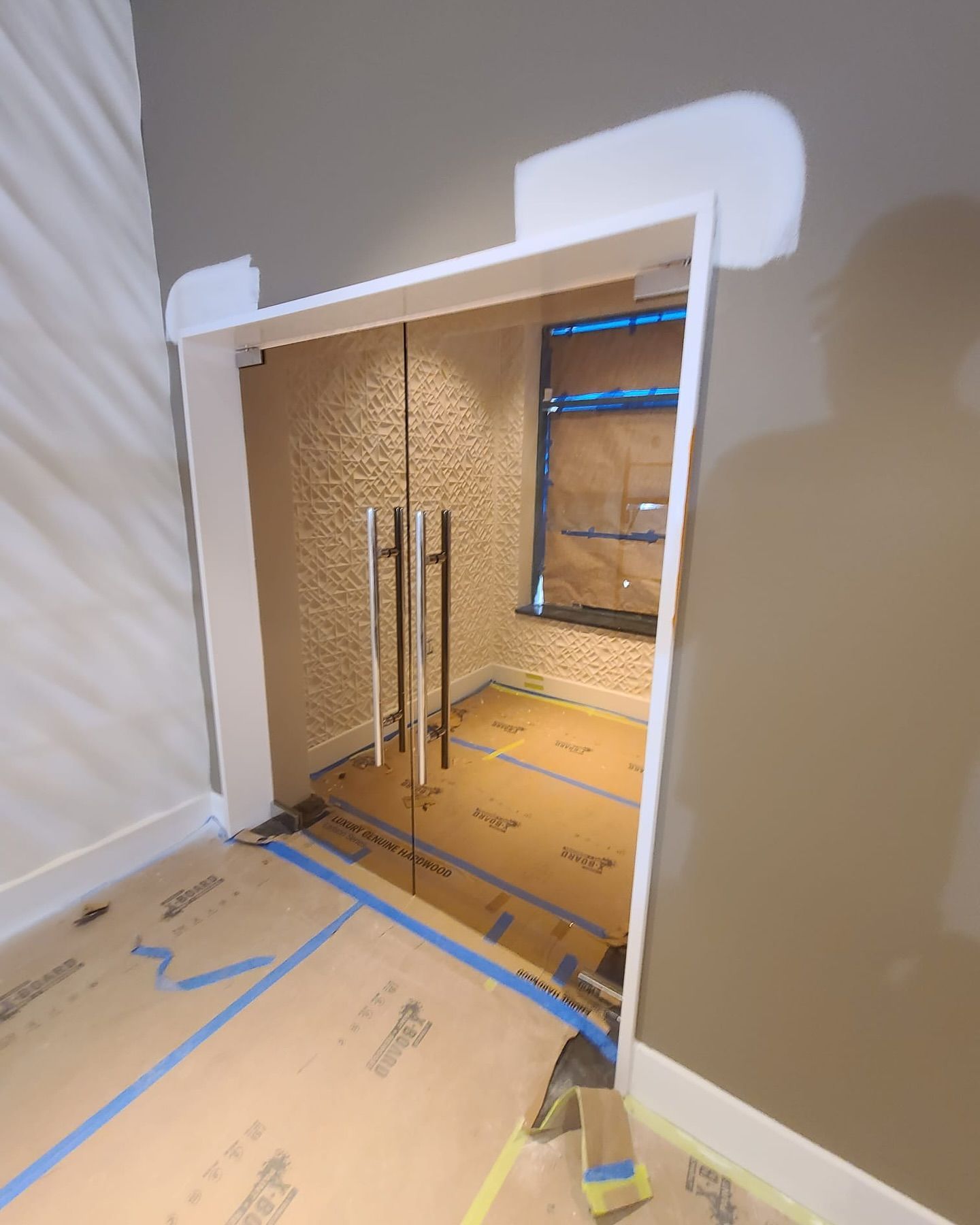 A room with a gray wall and a glass door