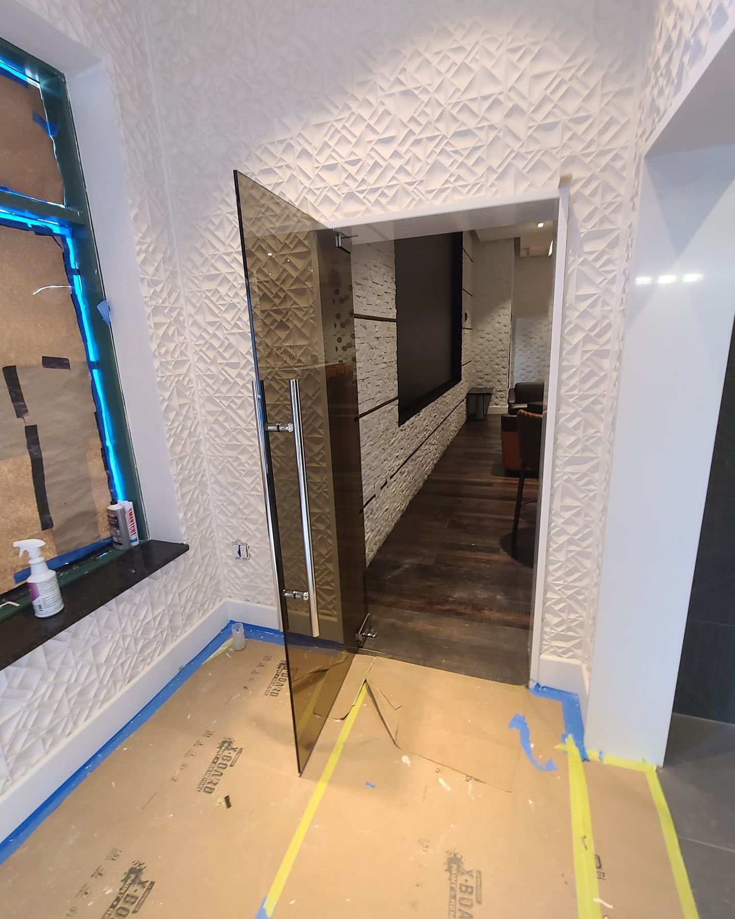 A hallway with a glass door and a window