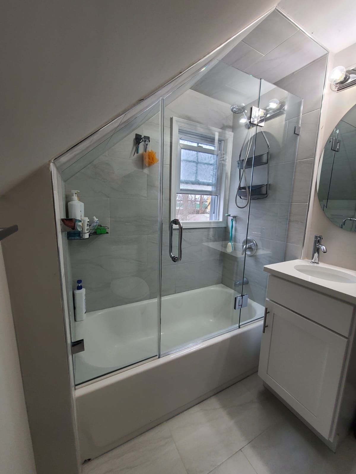 A bathroom with a bathtub , sink , mirror and shower stall.
