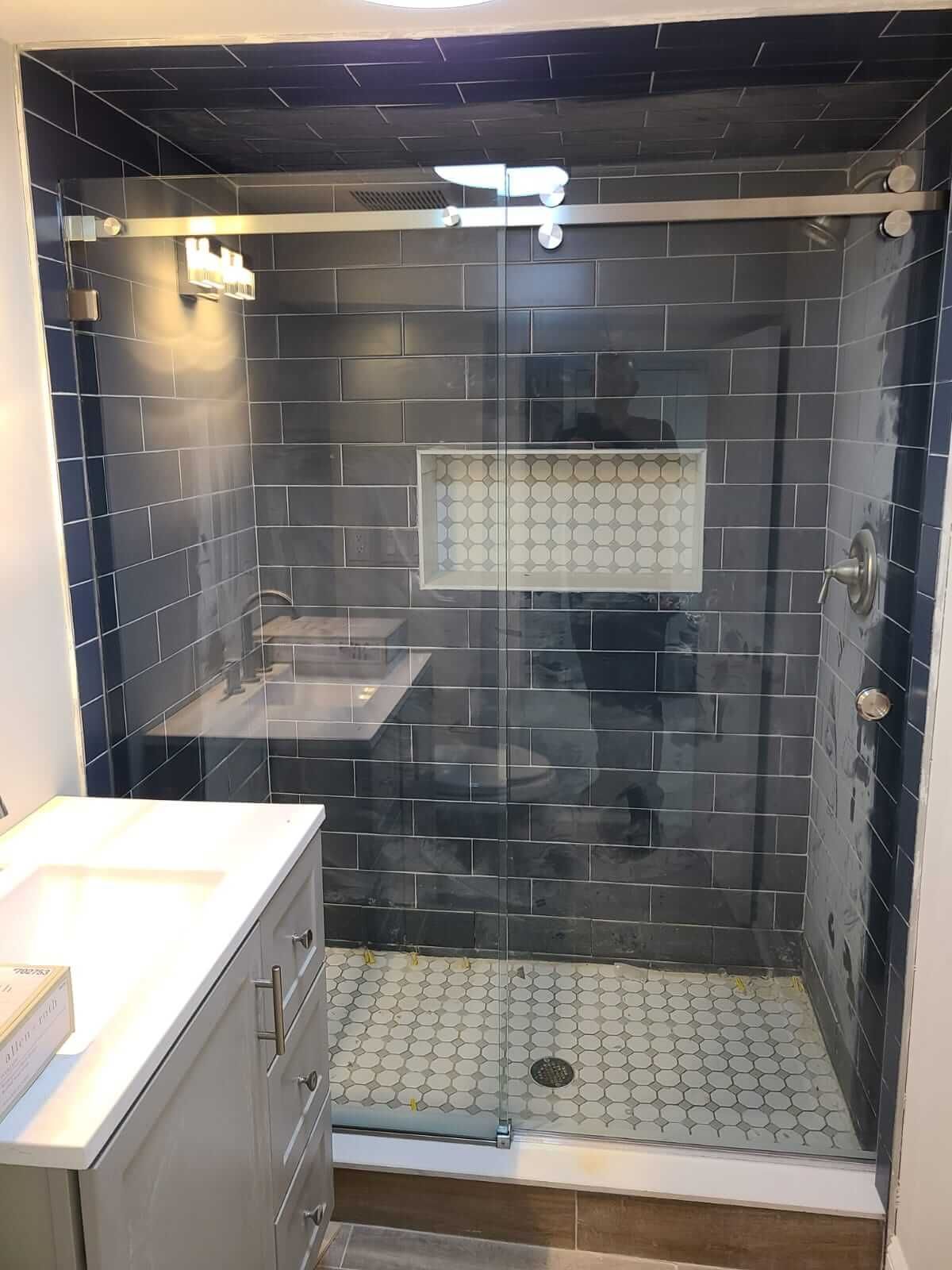 A bathroom with a sliding glass shower door and a sink.