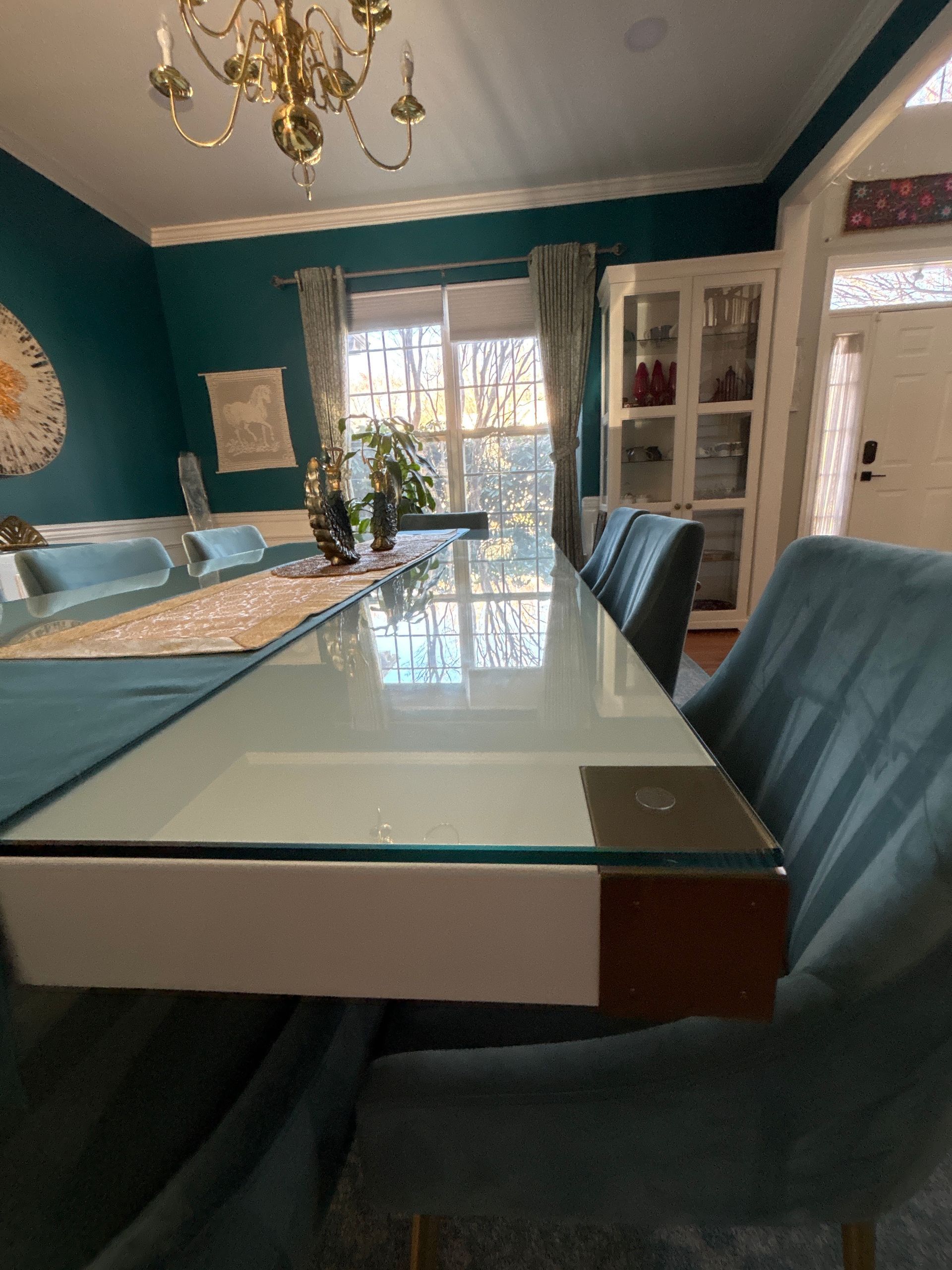 A dining room with a long glass table and chairs