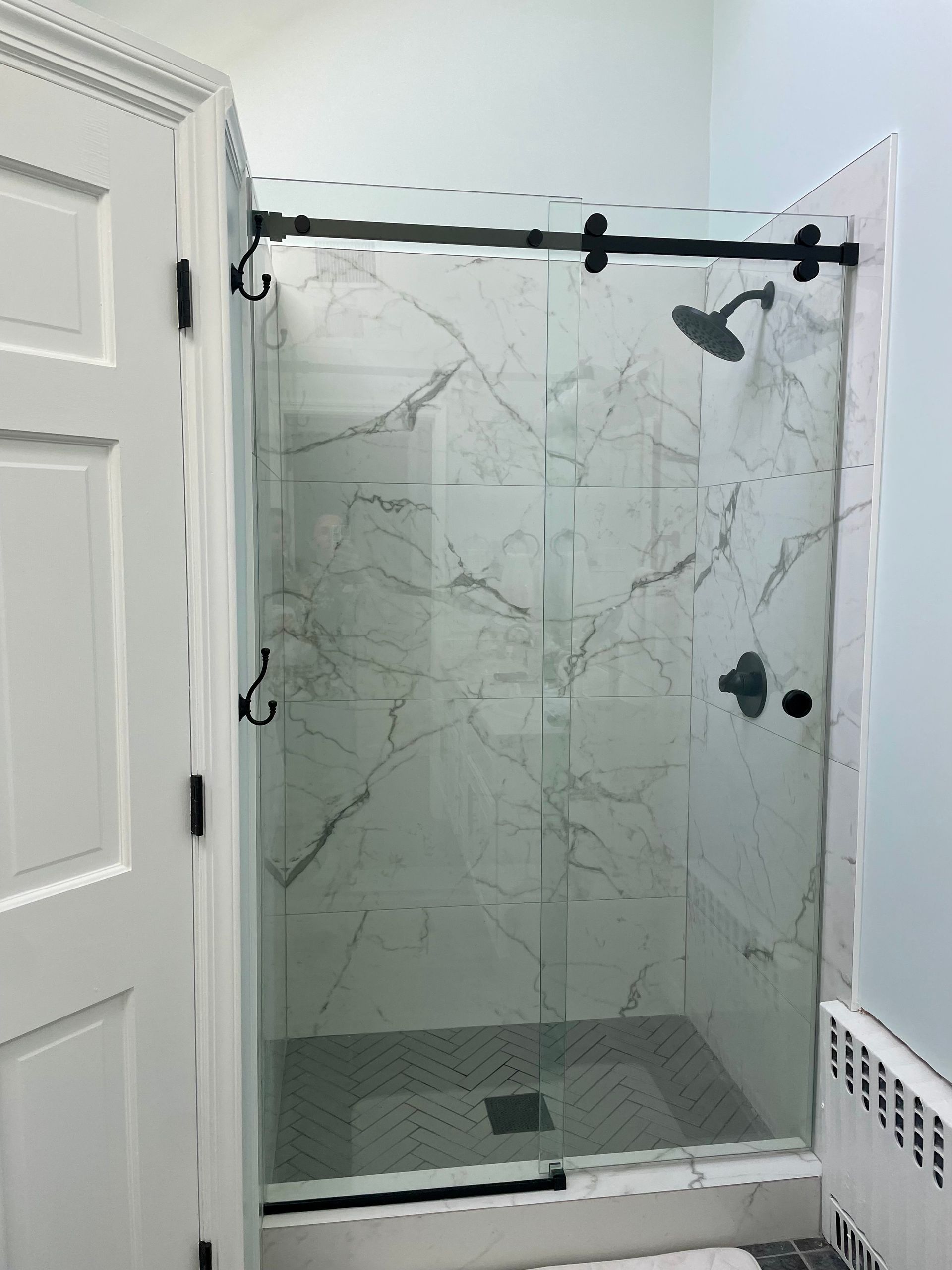 A bathroom with a sliding glass shower door and a shower head.