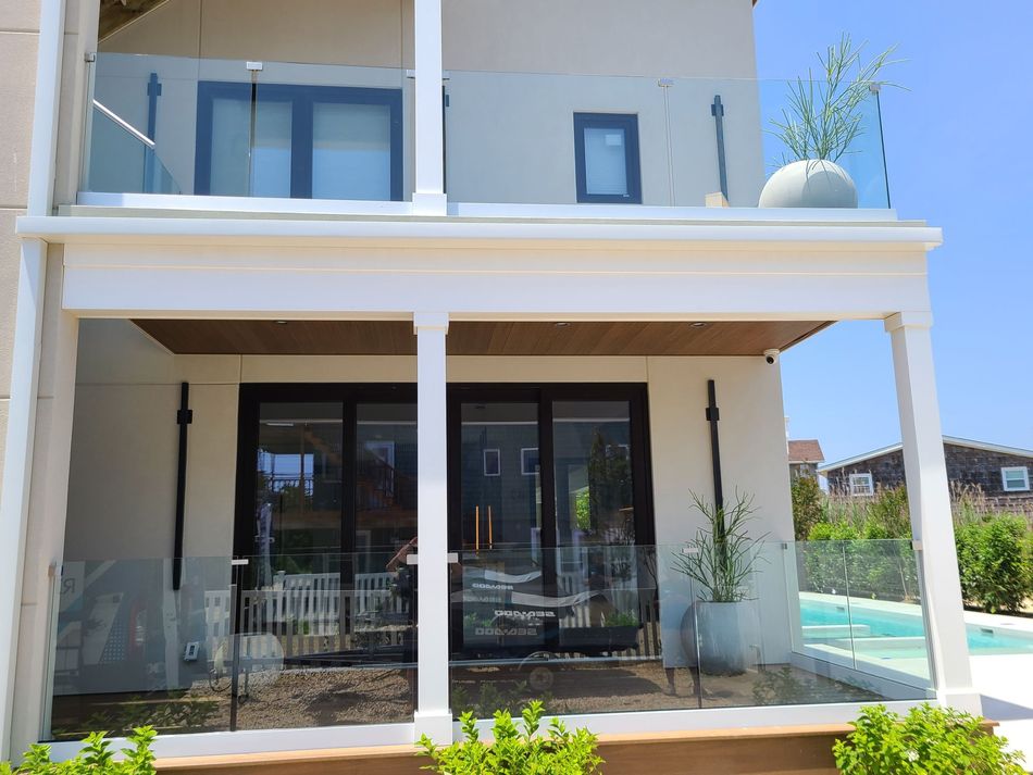 The back of a house with a balcony and a swimming pool.