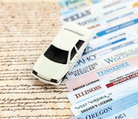 Toy car on top of several driver's licenses from different states.